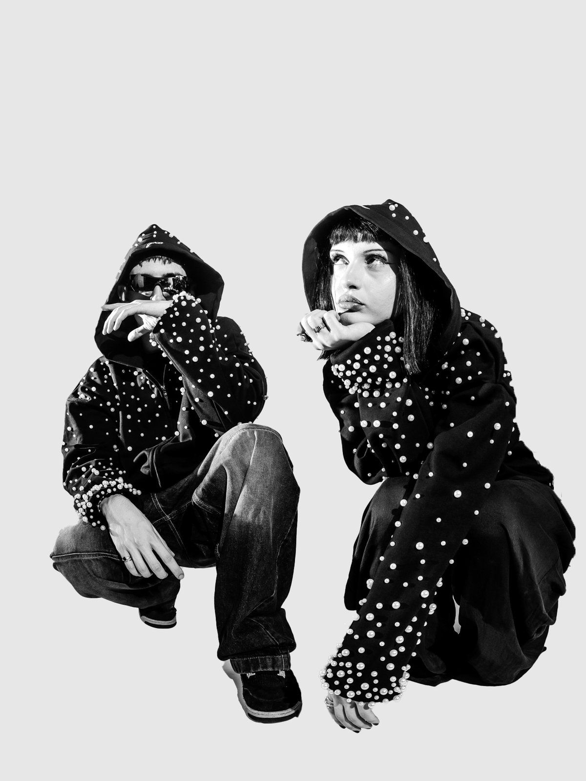Two people crouched in pearl zip-ups, one blowing a kiss